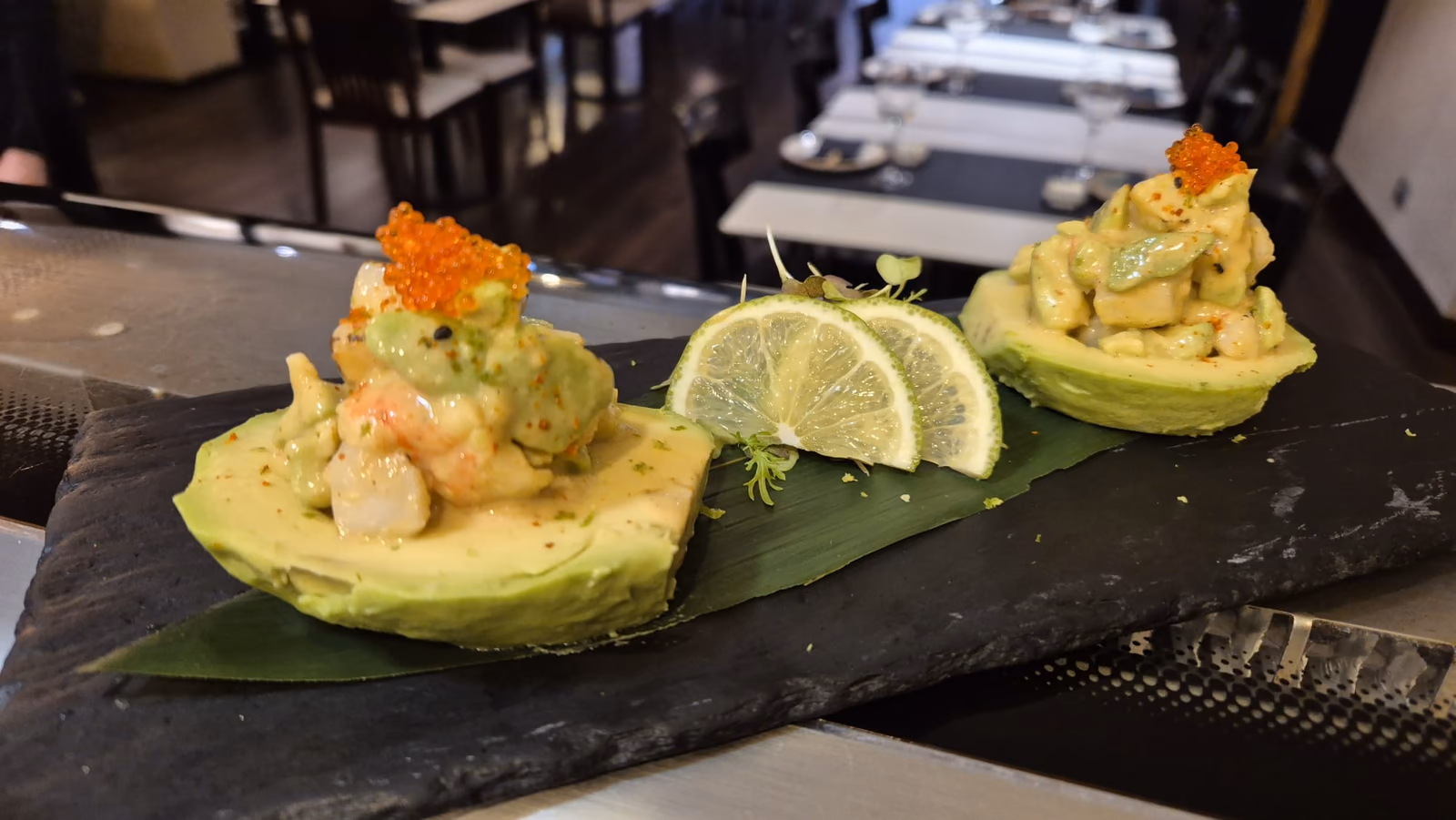 Aguacates rellenos de ensalada de langostino y hueva sobre pizarra en Hito