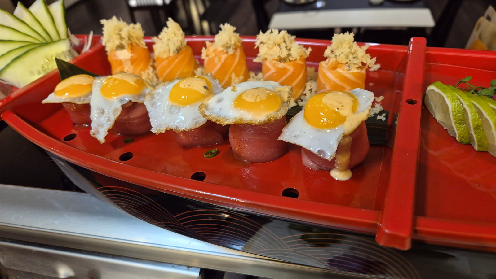 Un barco de sushi con rollos de salmón y atún coronados con huevo de codorniz en Hito