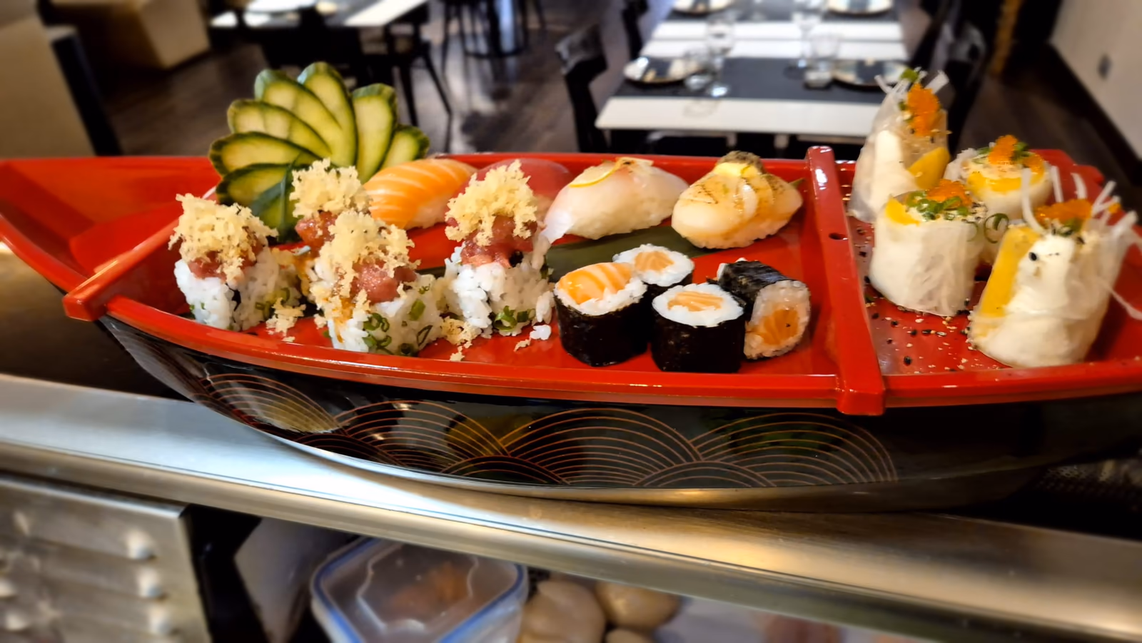 Un barco de sushi variado con nigiri, maki y uramaki en Hito