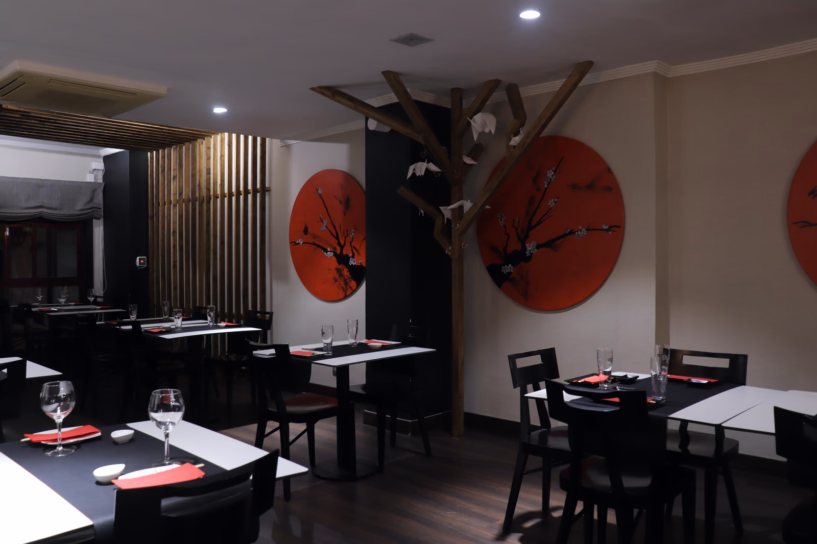 Comedor de Hito con murales de círculos rojos y una escultura de cerezo