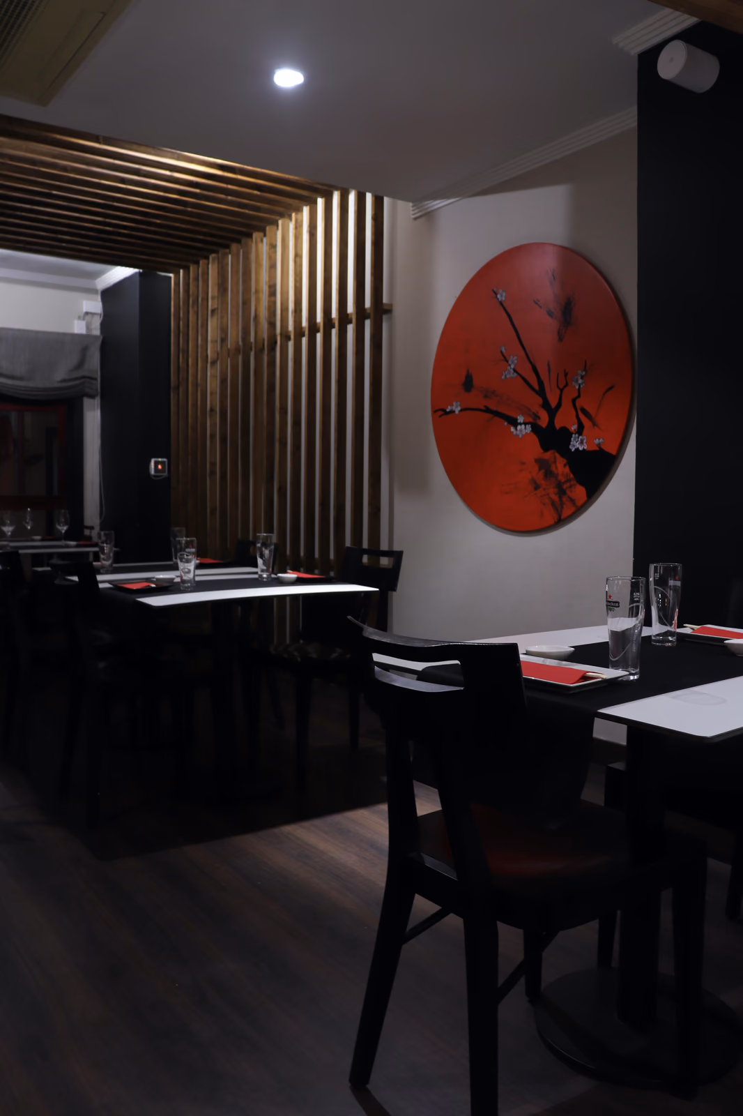 Hito dining room with a wooden lattice screen and cherry blossom mural